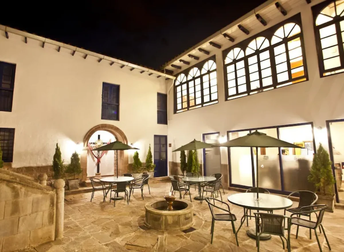 Common area at Tierra Viva Cusco Centro with a well-lit courtyard, tables, umbrellas, and colonial architecture.