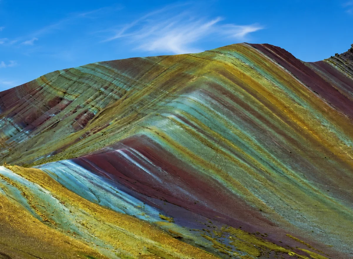 Montaña de Colores Palcoyo en Cusco con franjas naturales de colores, cielo despejado y paisaje andino de altura.
