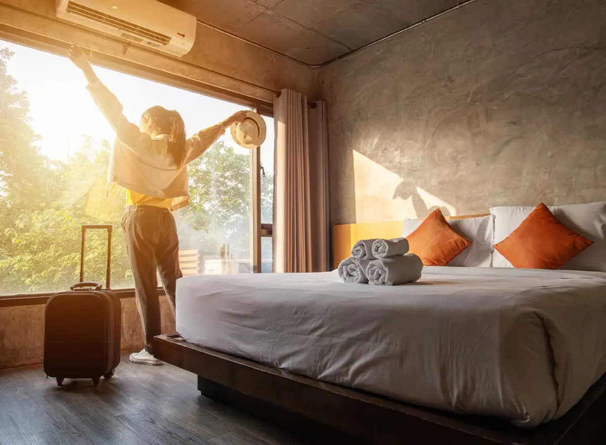 Hotel for solo travelers in Cusco: traveler in a comfortable room with a double bed, suitcase, and natural light after check-in.